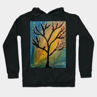 Black bird in the tree as the wind blows leaves off the tree Hoodie